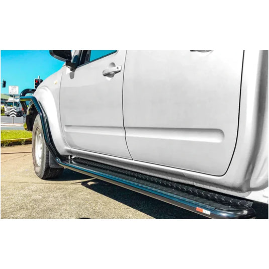 Silver pickup truck with black running boards featuring Rockarmor Brushbar for Nissan Navara